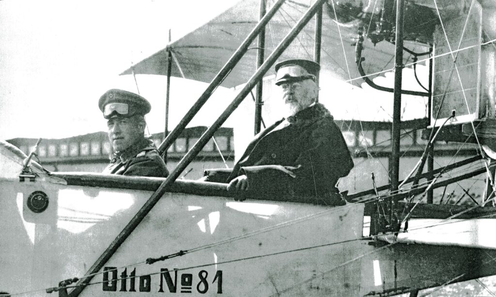 Graf Luitpold von Wolffskeel am Steuer des Otto-Doppeldeckers Nr. 81 mit dem Prinzen Leopold von Bayern als Passagier dahinter